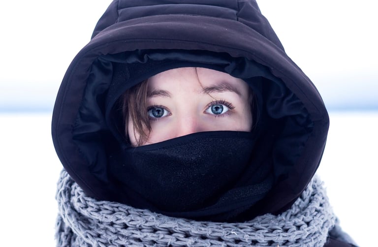 Photo couleur d'une femme portant une veste noire et un foulard autour du cou dans un pays froid