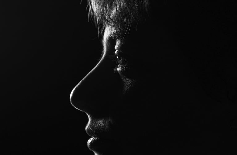 Dramatic black and white profile silhouette of a person's face using low-key lighting.