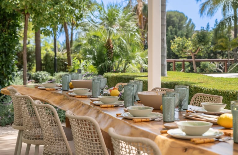 Outdoor dining table set within tropical gardens