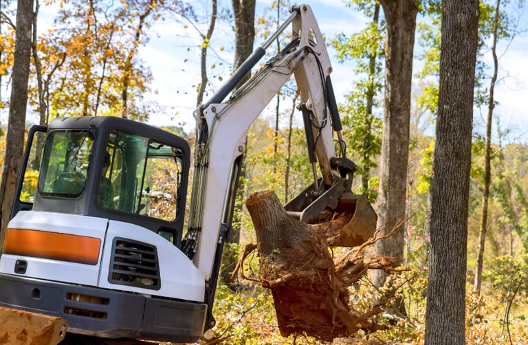mini-excavator-clearing-tree-stump.png