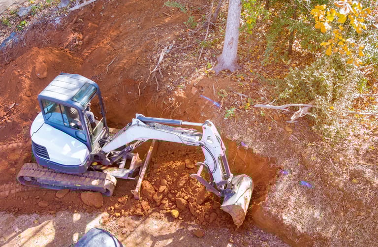 mini-excavator-digging-out-hillside.png