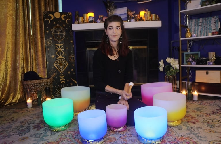 Image of a woman sitting with her crystal singing bowls