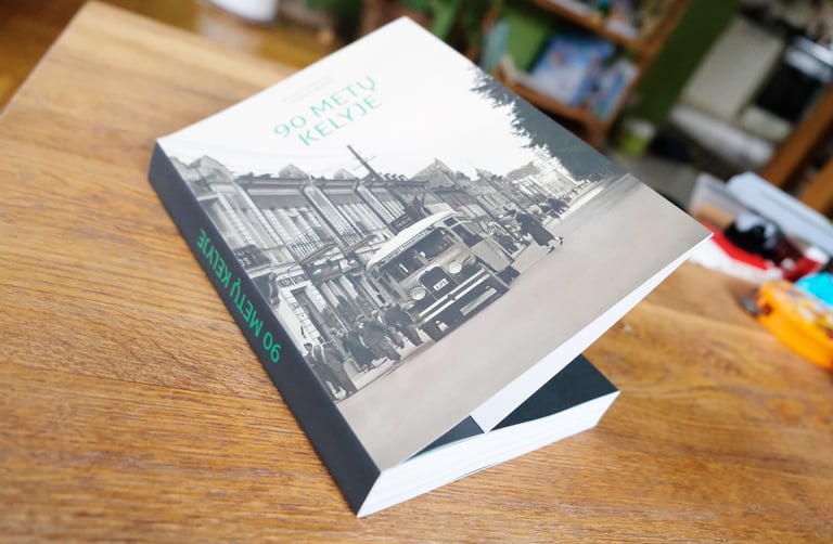 Book cover. The cover shows a vintage bus driving down Laisvės Alėja. 