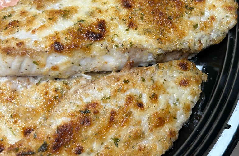 Broiled talapia with breading ready to eat on a plate.