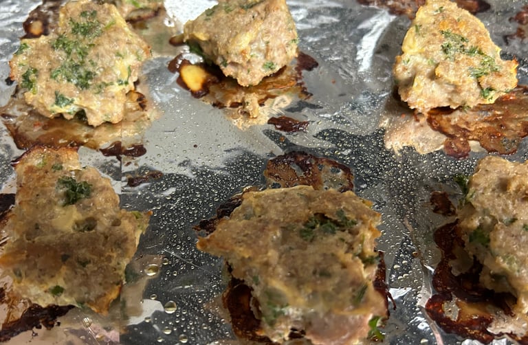 Turkey meatballs on pan covered in foil just after cooking in oven.