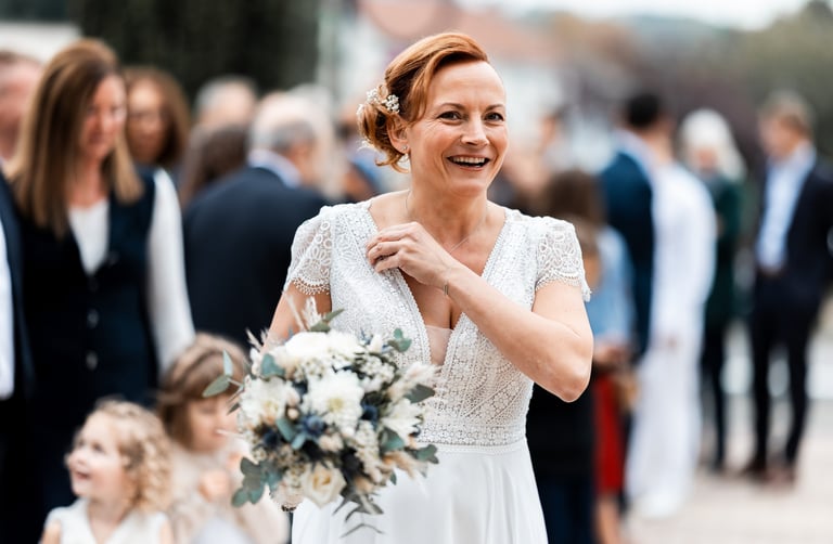 Une femme en robe de mariée un bouquet de fleurs à la main