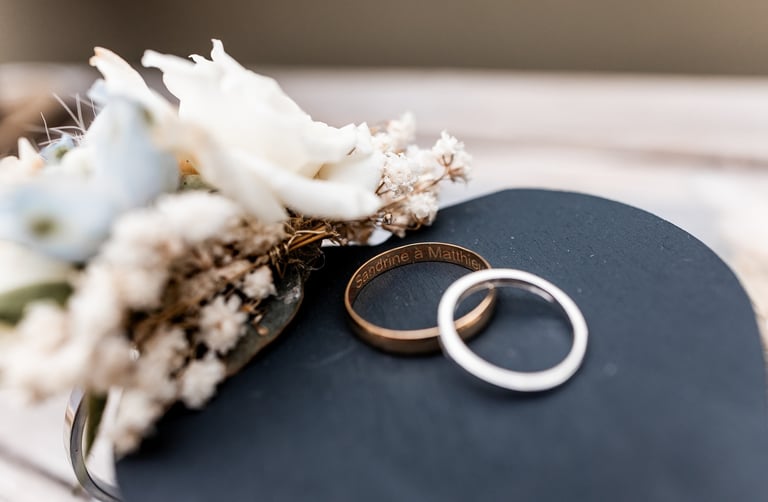 Deux alliances posées l'une sur l'autre près dune composition florale