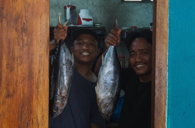 Timon and Rosi holding fresh tuna at the warung kitchen!