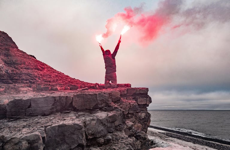 Survivor holding red flare near cliffside, emergency rescue signaling and coastal survival situation