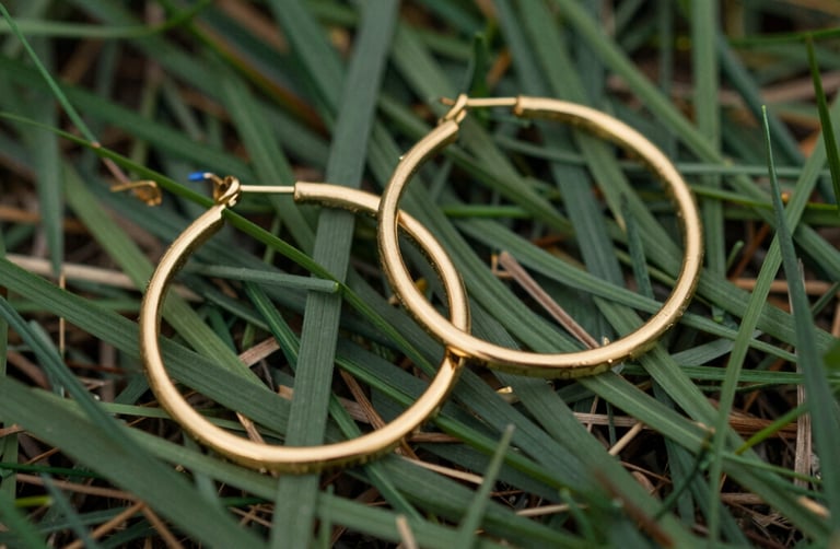 Elegant pair of silver hoop earrings displayed on a minimalist marble surface with soft natural light.