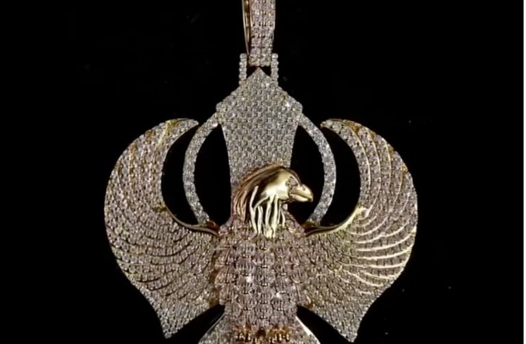 a gold - plated pendant with a bird on it