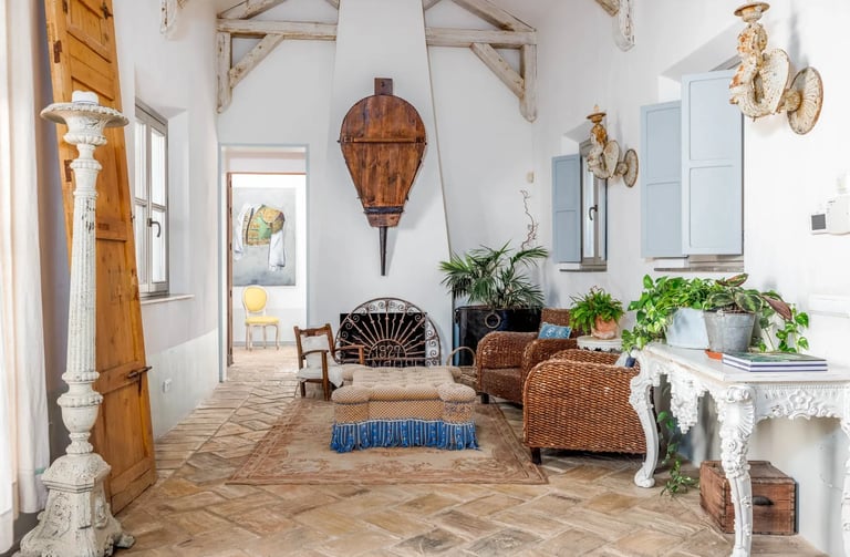 Rustic lounge with wicker chairs and fireplace at Finca Santa Katerina