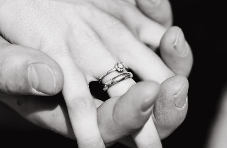 a person holding a ring with a diamond ring