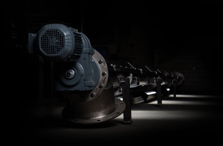 a row of industrial steel pipes with a black background