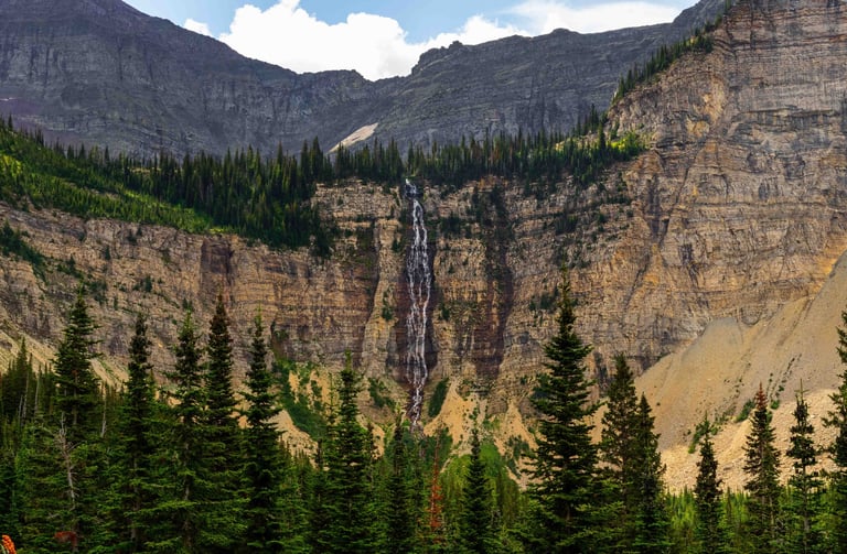 Crypt Falls cascading down a tall cliff in Waterton Lakes National Park, Alberta.