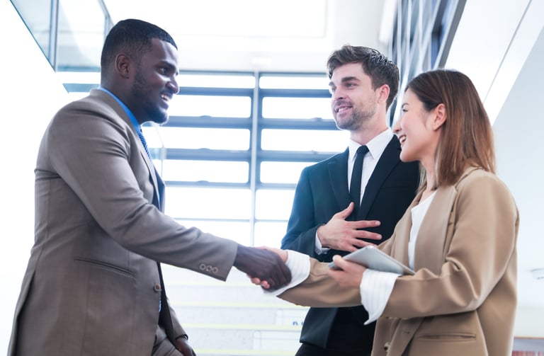 Business professionals shaking hands and referring one another 