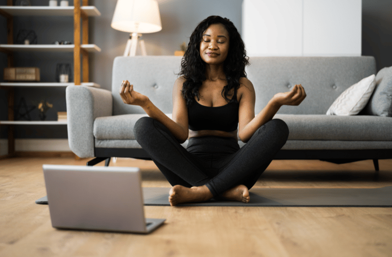 femme faisant du yoga devant son ordinateur