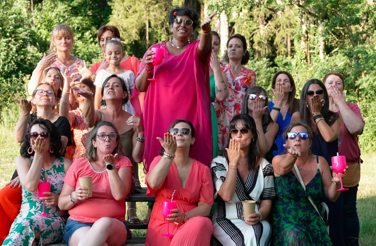 La mariée et ses copines font un bisou à la photographe de mariage