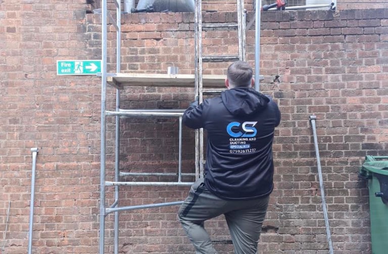 a man in cs cleaning and ducting company  workwear  fixing ducting