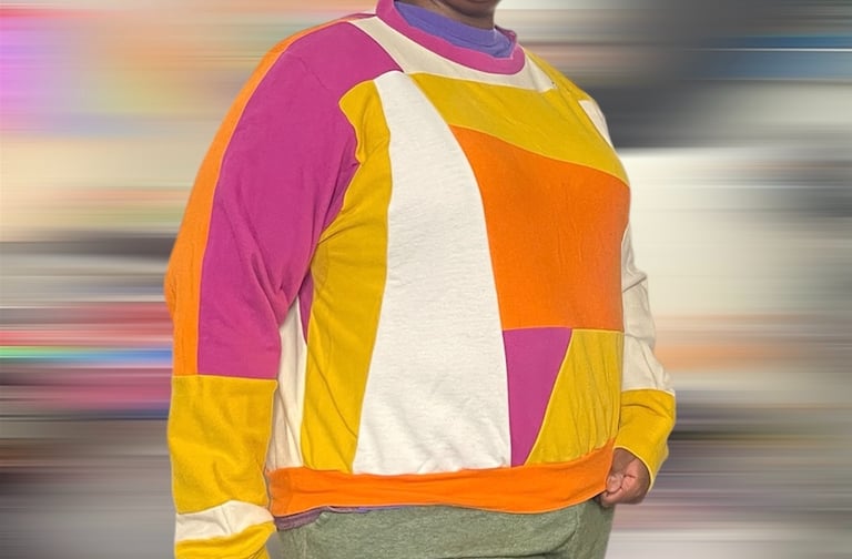 a black woman in a colorblock sweater and green pants