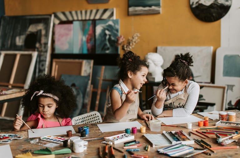 Imagem de crianças em uma mesa pintado quadros