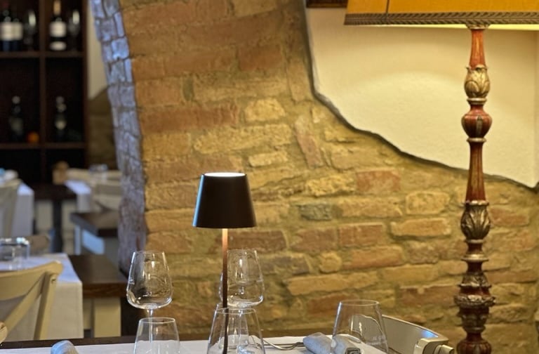Sala interna del ristorante con mura in mattoni tipici toscani e tavolo apparecchiato - Rustic indoo