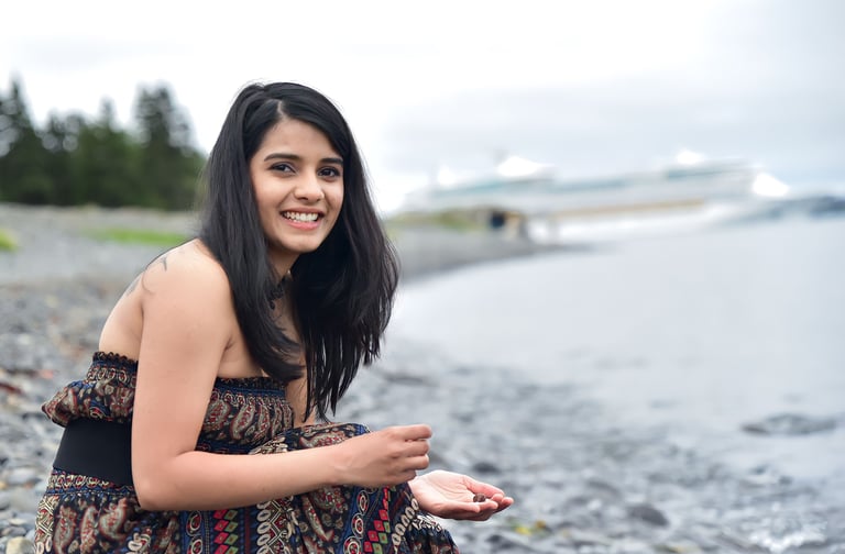 Dr. Rio Kashyap in a dress sitting on a beach