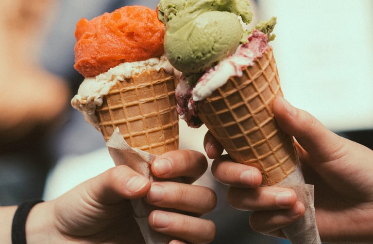 two ice cream cones one strawberry and one pistachio