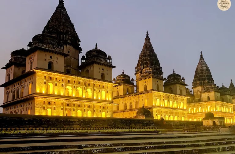 Orchha's royal cenotaphs illuminated at night.