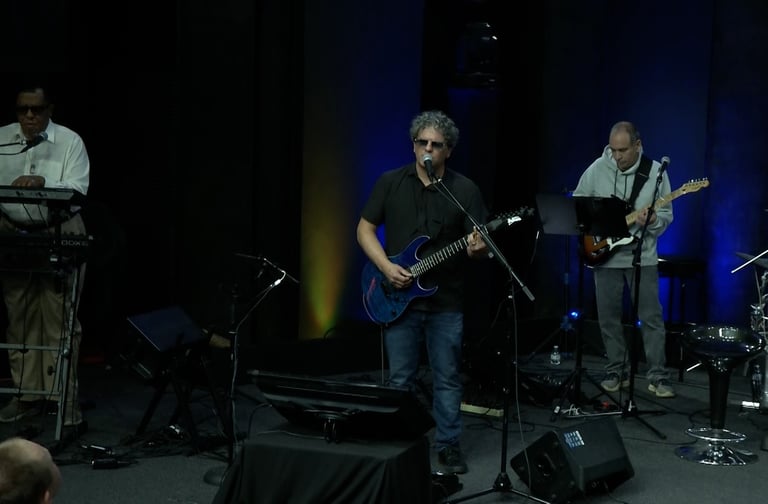 Sonny Cashbaugh and a band of musicians playing instruments on stage
