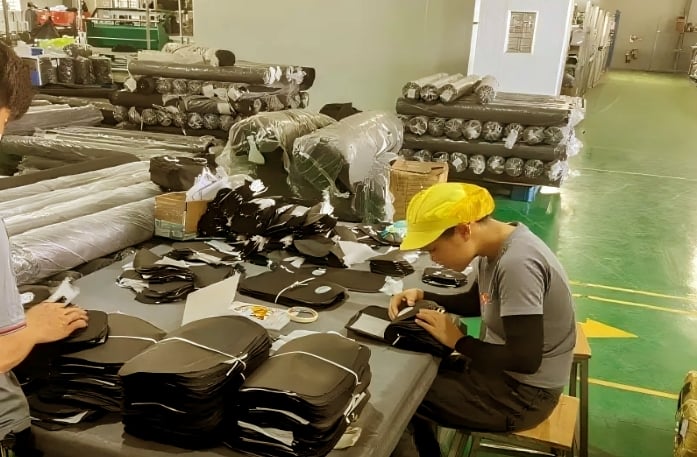 A King Fly team member performing meticulous quality control on a custom bag production line.