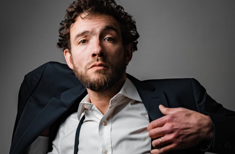 portrait studio couleur jeune homme qui enfile une veste. Book comédien © Virginie Bouilhac