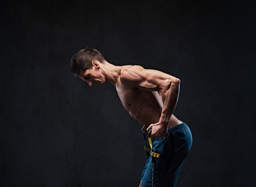 a man with a muscular body using resistance bands