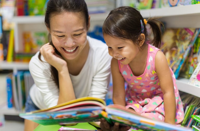 mom and toddler read a book together