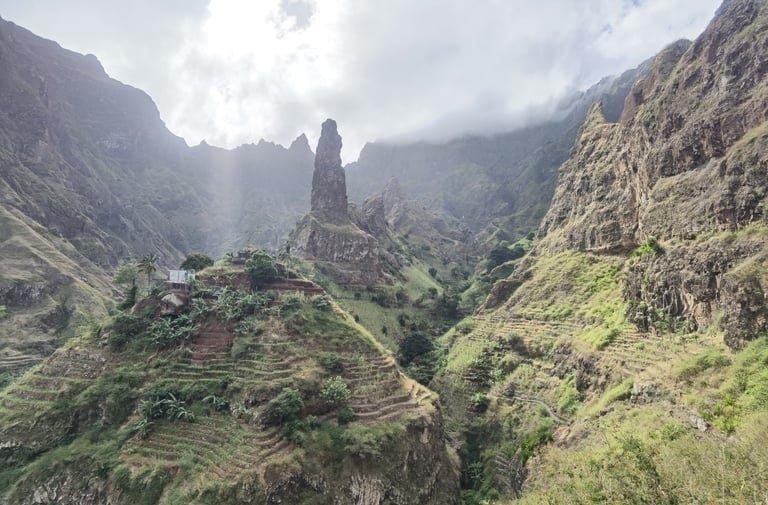 Verdant terraced hills and a towering rock spire in the volcanic mountains of Santo Antao, Cape Verde.
