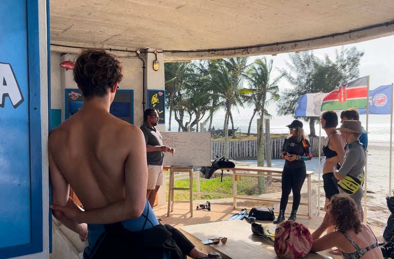 Scuba diving instructor giving a safety briefing to students on a tropical beach.