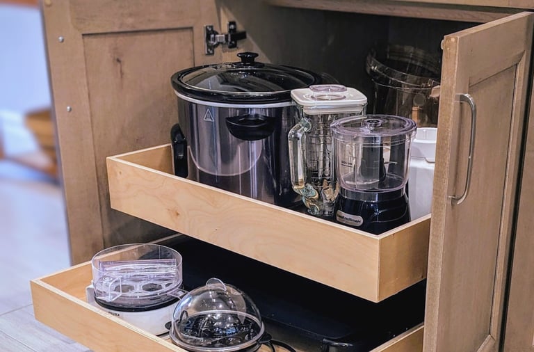 A cabinet drawer is extended out from the cabinet showing heavy kitchen appliances.