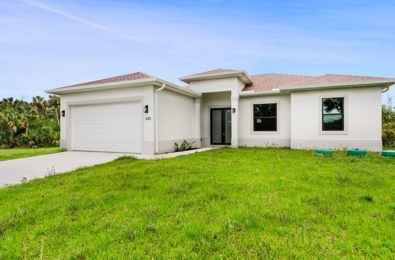 Beautifully designed front elevation of a new home for sale in Lehigh Acres, Florida. 3 beds + den, 