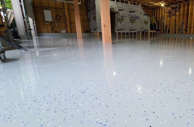 Glossy epoxy with sporadic flake install with smooth seamless floor with 45 degree coving 
