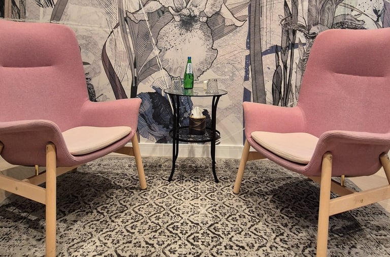 Wnętrze gabinetu Marty Krężołek. Pastelowe, łagodne barwy oraz dwa wygodne fotele przy terapii indywidualnej