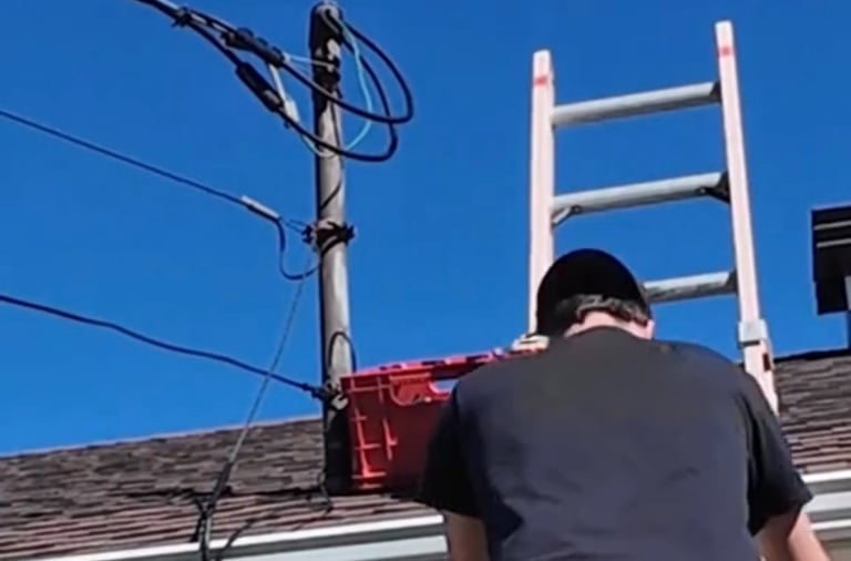 Électricien effectuant la réparation d'un branchement électrique résidentiel d'urgence.