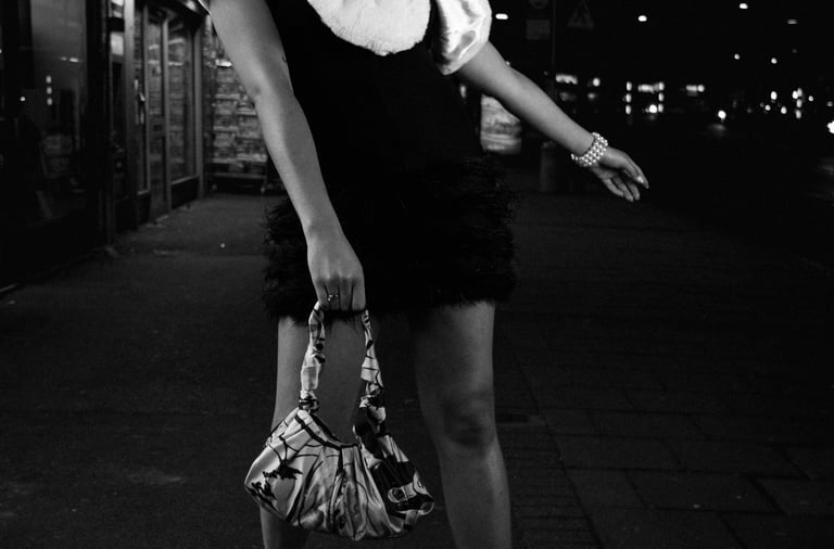 Black and white night street portrait of a woman in an urban setting
