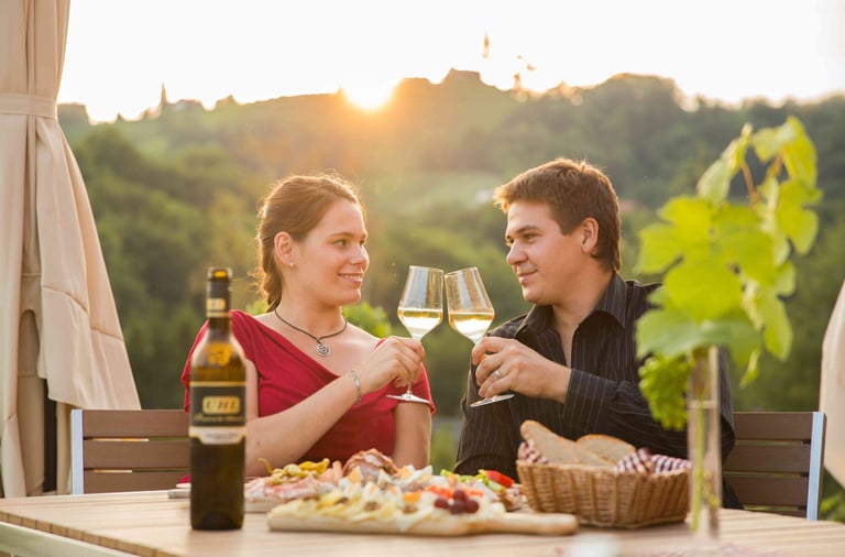 Ein Pärchen das mit zwei Weingläsern anstoßt