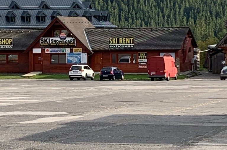 a parking lot with a lot of cars parked in front of a building