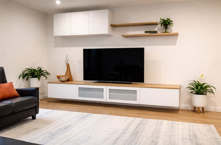 Modern white floating TV unit with wooden top and matching wall shelves in a minimalist living room.