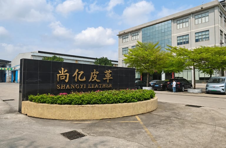 Shangyi Leather factory exterior with a black marble company sign and modern office building.