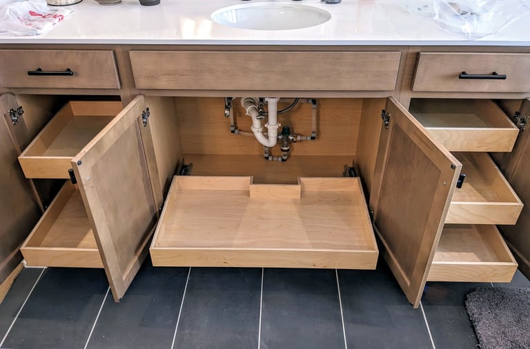 A bathroom vanity with roll out shelving in the bottom spaces, making storage more convenient.