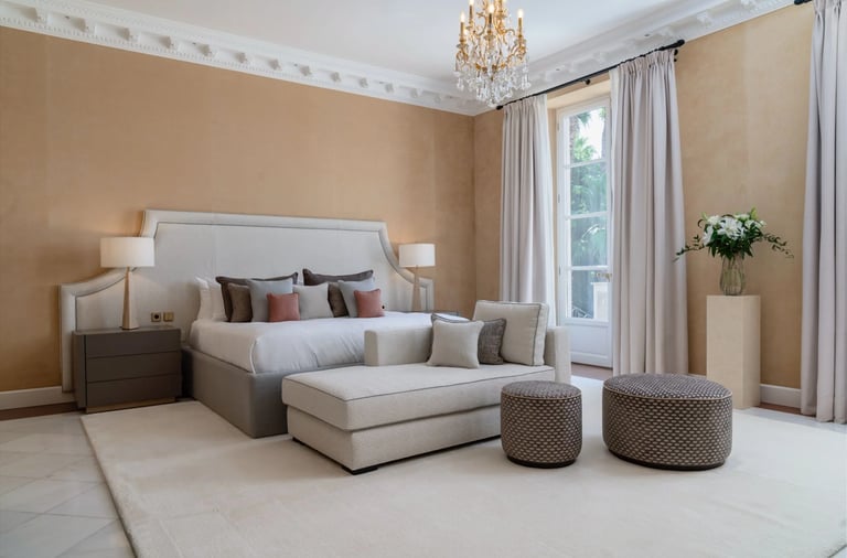 Elegant neutral-toned bedroom with lounge area