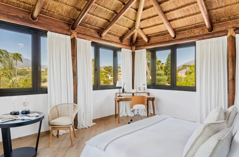 Penthouse suite with thatched ceiling and panoramic mountain views at Villa El Olivo, Marbella