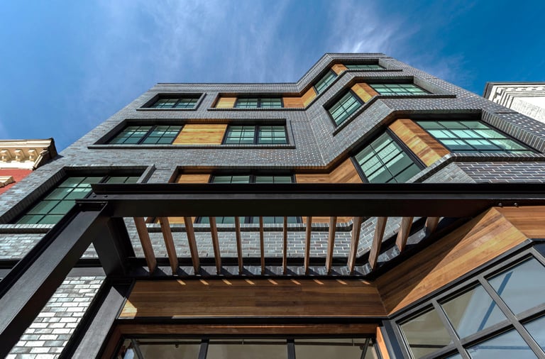 An architectural photograph of a grey brick apartment building